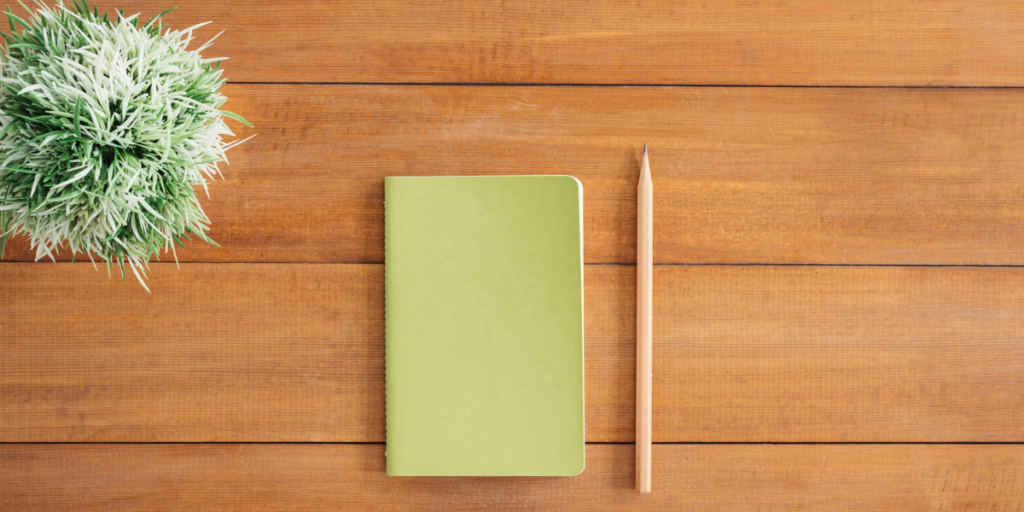 Light green journal with a pencil.