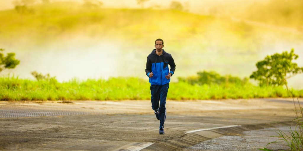 Young man on a run with a yellow sky behind him.