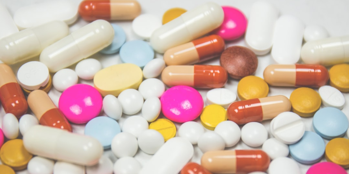 An assortment of colorful pills on a white table.