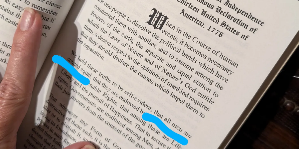 A textbook that shows the Declaration of Independence, with "that all men are created equal" highlighted.