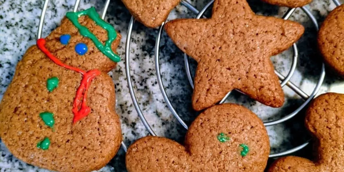 Ginger bread cookies shaped like snowmen on a drying rack.