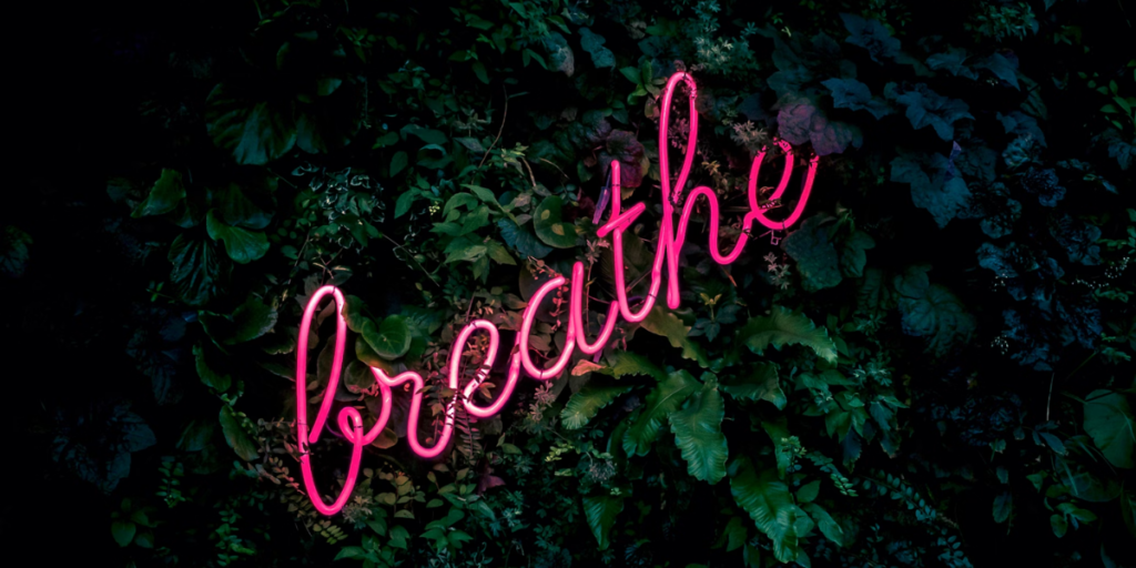 A neon sign that says "breathe"