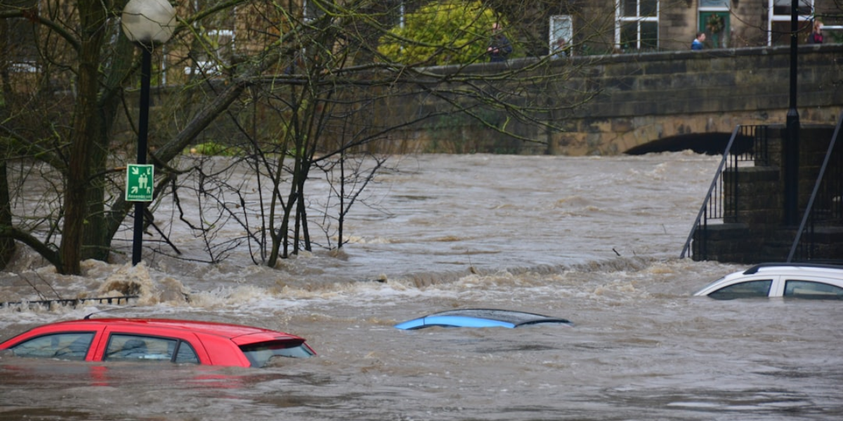 3 cars almost fully submerged underwater in a flood.