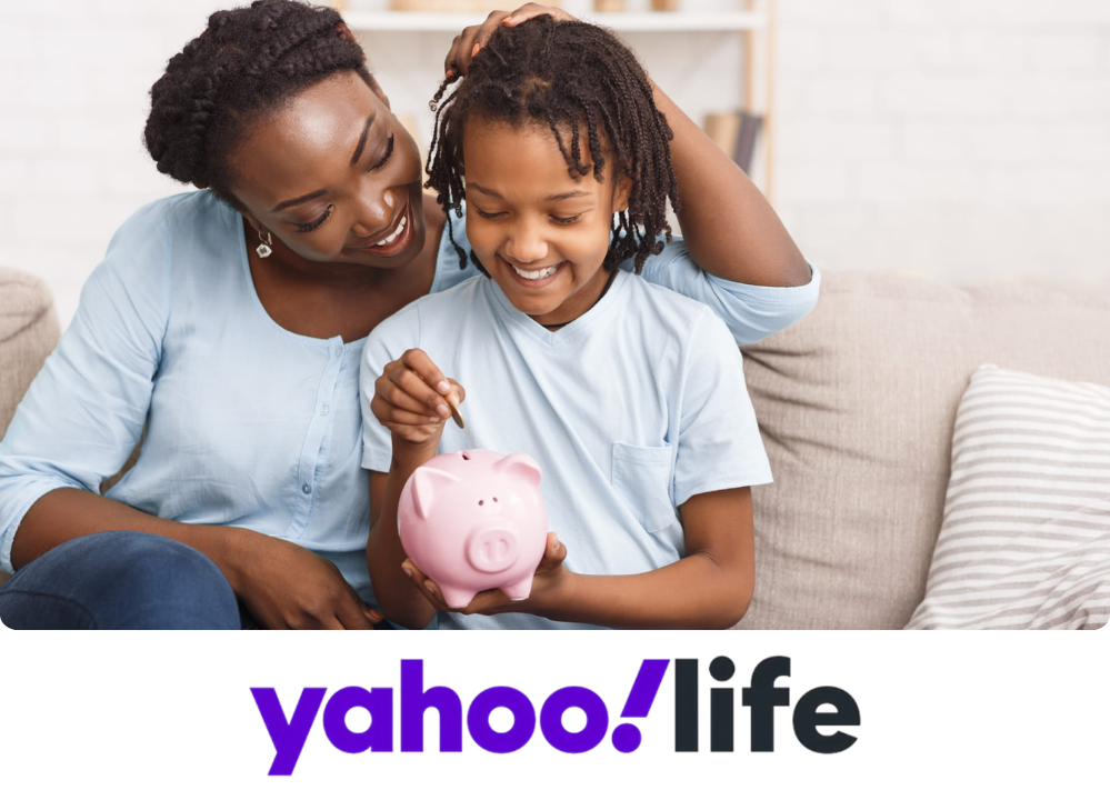 Stock Image of a mom and child sitting on the couch, both smiling, and the child is putting a coin in a piggy bank.