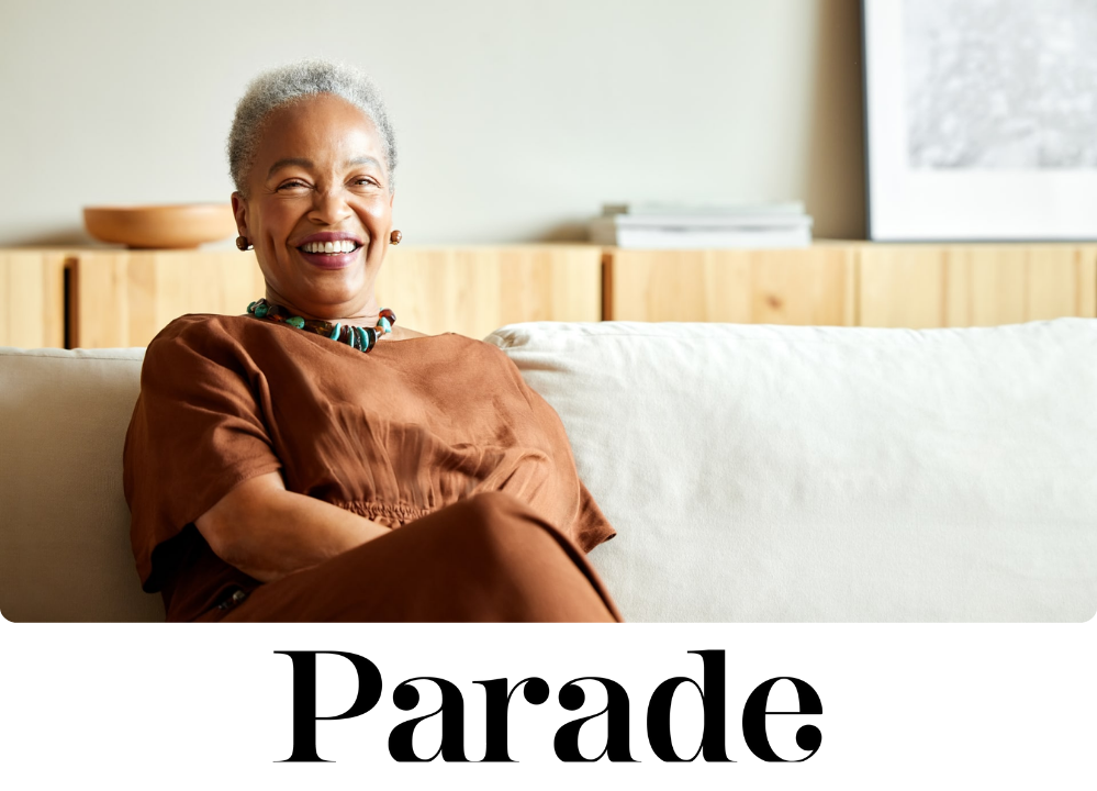 Stock image of a woman smiling while sitting on the couch.