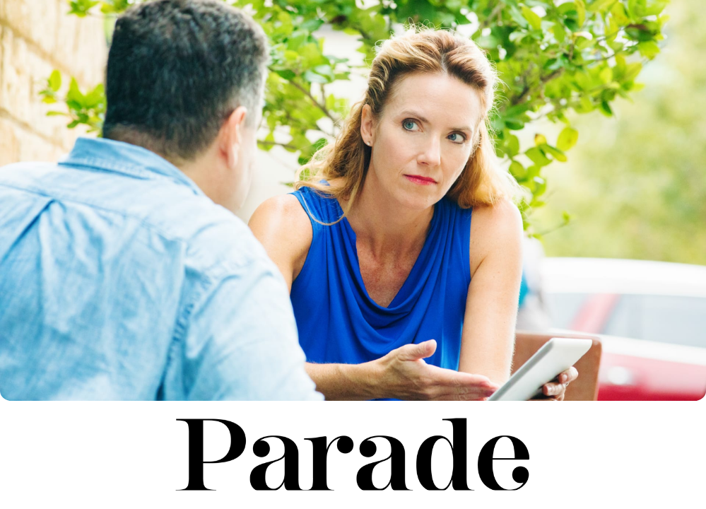 A woman looking sharply at a man across the table from her and she's pointing to an ipad.