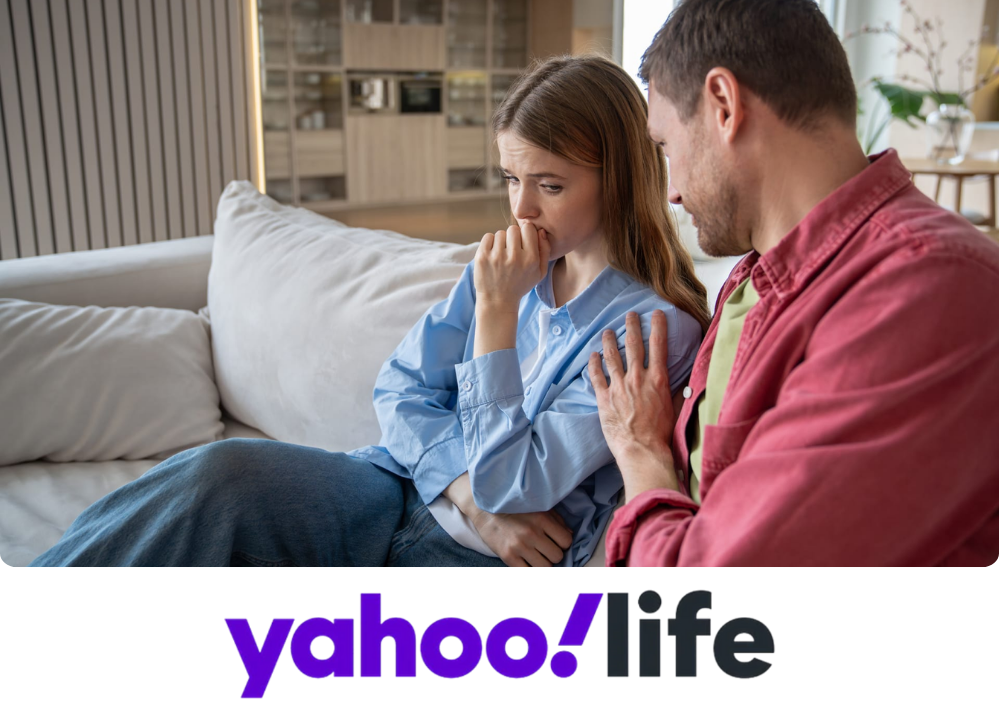 Stock image of a man comforting a woman on a couch.