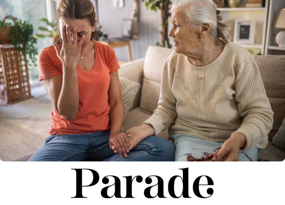 Stock Image of a younger woman looking distressed, sitting on a couch next who an older woman, who is offering a helping hand.